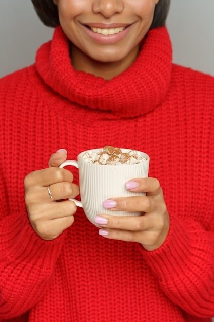 A close-up shot of a woman's hands holding a warm cup of coffee while wearing a blush pink ribbed knit Shein loungewear set. The focus is on the texture of the knit fabric and the comforting atmosphere created by the coffee and soft lighting.