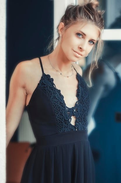 A close-up shot of a woman wearing a stylish little black dress from Shein. The dress is knee-length and has delicate lace detailing on the neckline. She is wearing elegant silver jewelry.
