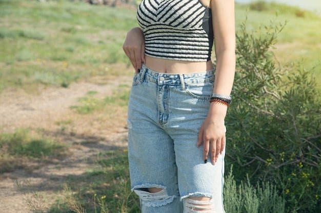 A close-up shot of a pair of light wash denim shorts from Shein styled with a tucked-in striped nautical top and a woven belt. A straw tote bag and espadrille sandals are placed beside the shorts, showcasing a perfectly curated vacation outfit.