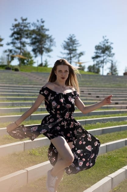 A stylish young woman is featured at an outdoor concert, wearing a Shein-sourced outfit that includes a graphic tee, ripped jeans, and a lightweight denim jacket tied around her waist. The image focuses on the interplay of textures and layers, showcasing a practical yet fashionable concert look. Soft, natural lighting enhances the scene, capturing the vibrant atmosphere of the event.