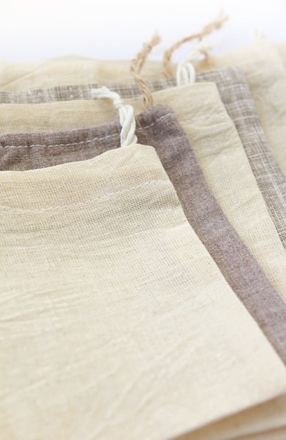 A close-up shot of various sustainable fabrics, including organic cotton, recycled polyester, and linen. The textures of the fabrics are clearly visible, showcasing their natural and eco-friendly qualities. The image conveys a sense of sustainability, responsibility, and quality.