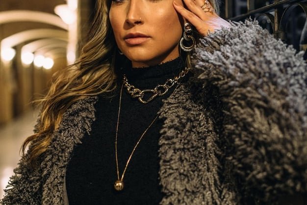 A close-up shot of a woman wearing multiple layered necklaces from Shein, including a delicate gold chain and a pendant necklace, with a blurred background of a city street.